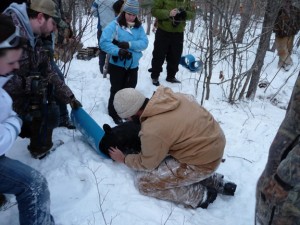 Dave McFarland adds lubricating ointment and closes the eyelids of a sedated boar cub. 